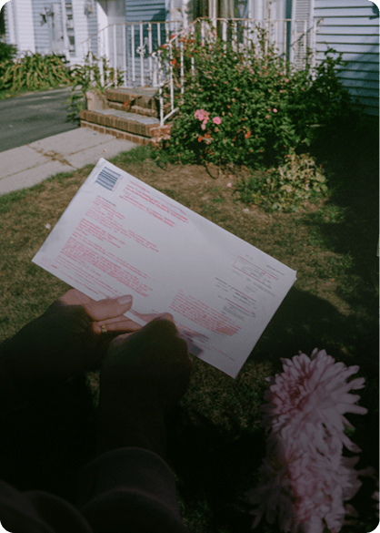 Holding the prepaid return envelope outside a house